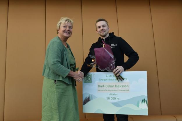 Karl-Oskar Isaksson mottar utmärkelsen &Aring;rets unga skogsentreprenör 2022 från Maud Petri Rådström, ansvarig för Skogssektionen, Gröna arbetsgivare.